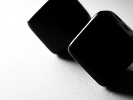 Dois dados pretos em superfície branca mate